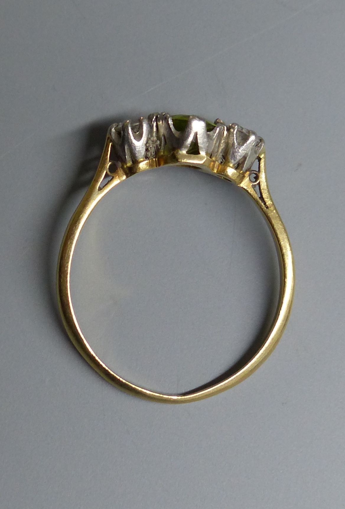 An 18ct and plat. peridot and diamond set three stone ring, size N, gross 2.5 grams.